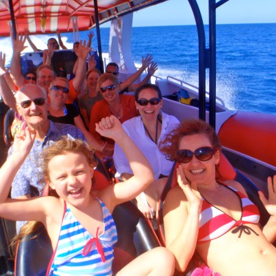 a group of people sitting in a boat on a body of water